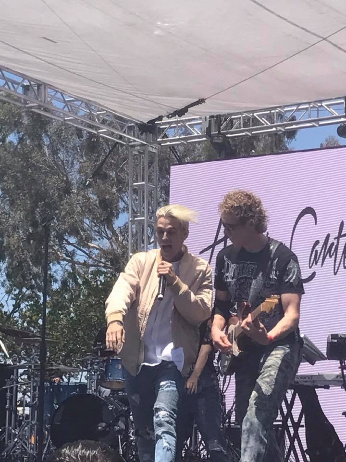 Aaron Carter singing on stage while Erik Madsen plays guitar beside him at Wango Tango 2017